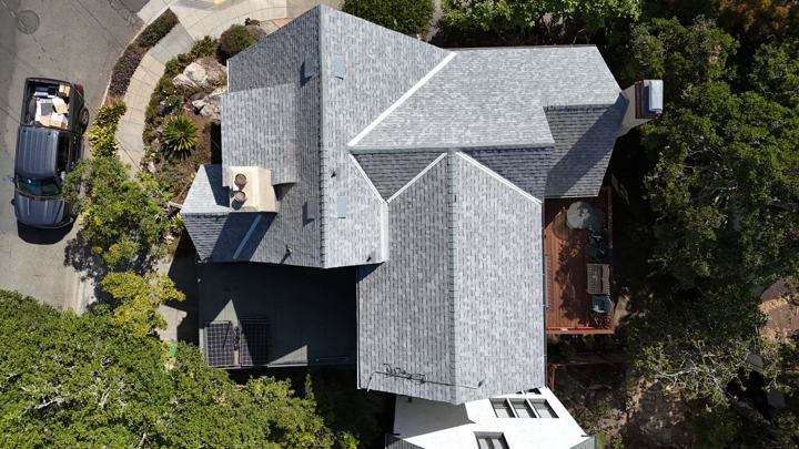 Gray shingles on a large home by Precise Roofing